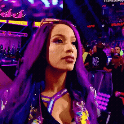 A Woman With Purple Hair Is Standing In Front Of A Crowd In A Stadium . GIF