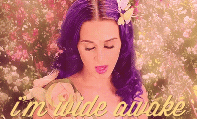 A Woman With Purple Hair Is Surrounded By Flowers And The Words " I 'M Wide Awake " Are On The Bottom GIF