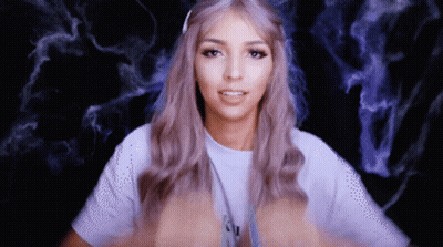 A Woman With Purple Hair Is Wearing A White T-Shirt With The Letter N On It GIF