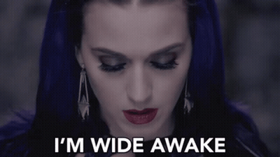 A Woman With Purple Hair Says " I 'M Wide Awake " In White Letters GIF