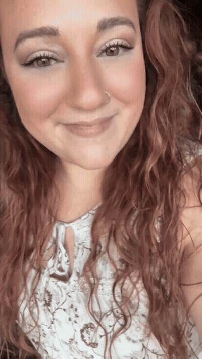 A Woman With Red Hair And A Nose Ring Smiles GIF