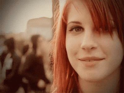 A Woman With Red Hair And A Piercing In Her Lip Smiles GIF