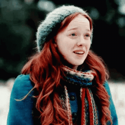 A Woman With Red Hair And A Scarf Is Wearing A Hat And Scarf . GIF
