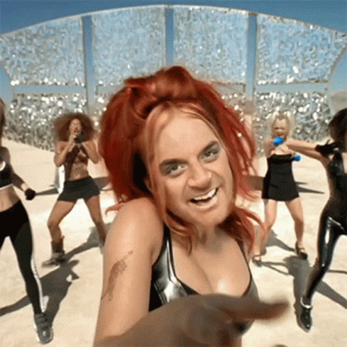 A Woman With Red Hair And A Tattoo On Her Arm Is Dancing With A Group Of Women GIF