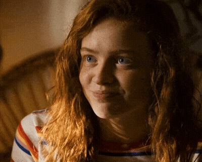 A Woman With Red Hair And Blue Eyes Is Smiling For The Camera GIF