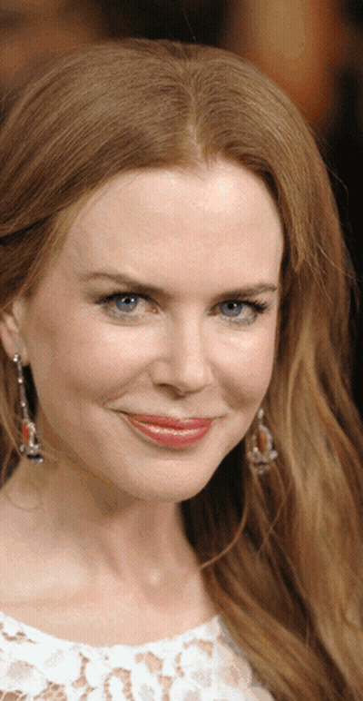 A Woman With Red Hair And Blue Eyes Is Smiling GIF