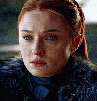 A Woman With Red Hair And Blue Eyes Is Wearing A Black Fur Coat GIF