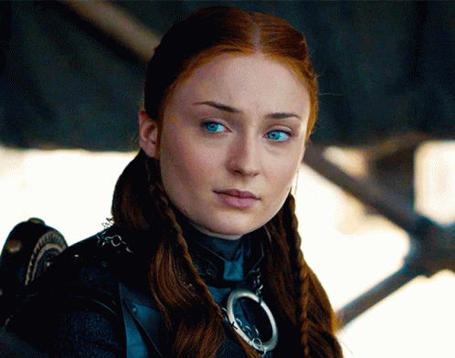 A Woman With Red Hair And Blue Eyes Is Wearing A Necklace GIF