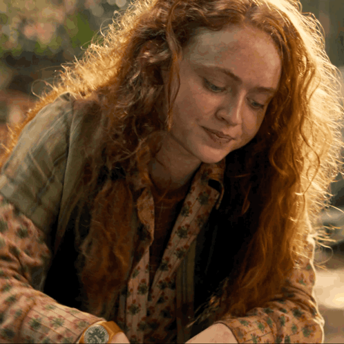 A Woman With Red Hair And Freckles Is Wearing A Watch GIF
