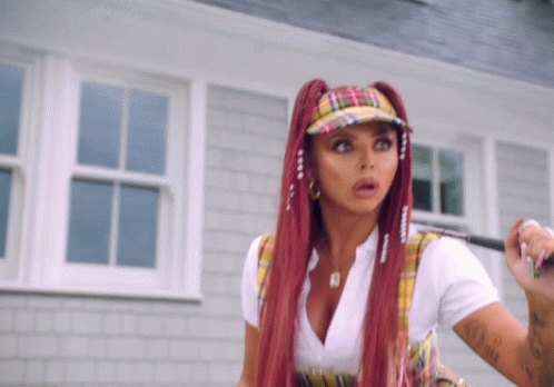 A Woman With Red Hair And Plaid Hat Holds A Golf Club GIF