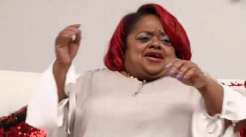 A Woman With Red Hair And White Nails Is Making A Face GIF
