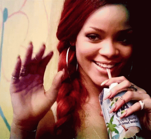 A Woman With Red Hair Drinking A Carton Of Coconut Water GIF