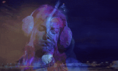 A Woman With Red Hair Is Dancing In A Dark Room GIF