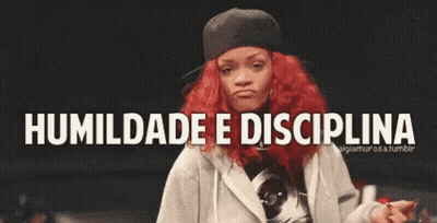 A Woman With Red Hair Is Dancing In Front Of A Sign That Says Humildade E Disciplina . GIF