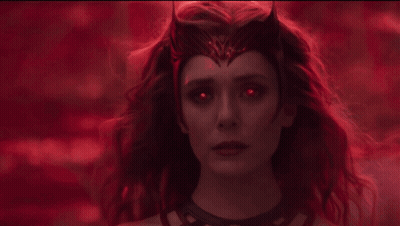 A Woman With Red Hair Is Holding A Red Glowing Object In Her Hand GIF