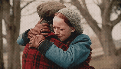 A Woman With Red Hair Is Hugging A Man In A Plaid Jacket GIF
