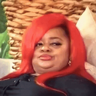 A Woman With Red Hair Is Laying On A Couch And Making A Face . GIF