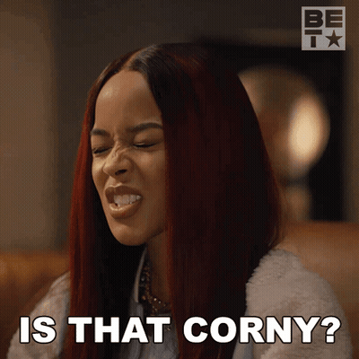 A Woman With Red Hair Is Making A Funny Face And Says " Is That Corny " GIF