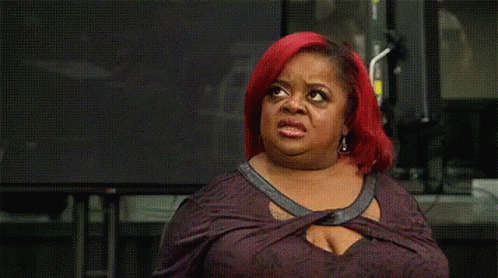 A Woman With Red Hair Is Making A Funny Face In Front Of A Television . GIF