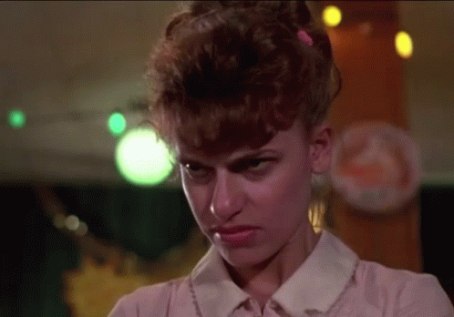 A Woman With Red Hair Is Making A Funny Face GIF