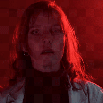A Woman With Red Hair Is Saying " You 'Ve Been A " In A Dark Room GIF