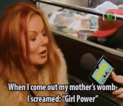 A Woman With Red Hair Is Screaming Into A Microphone While Holding A Card That Says " Girl Power " GIF