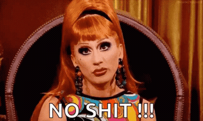 A Woman With Red Hair Is Sitting In A Chair And Saying `` No Shit !!! '' . GIF