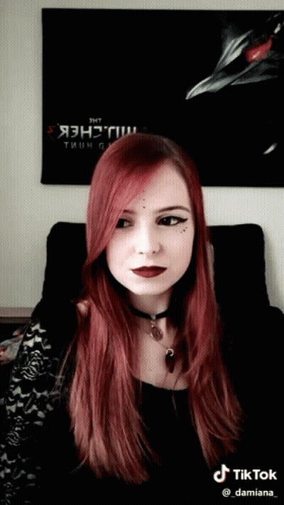 A Woman With Red Hair Is Sitting In Front Of A Poster That Says " Jht " GIF