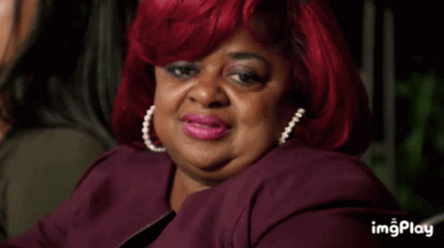 A Woman With Red Hair Is Sitting Next To Another Woman In A Dark Room With The Words Imgplay Below Her GIF