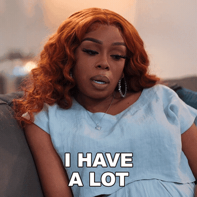 A Woman With Red Hair Is Sitting On A Couch And Saying I Have A Lot GIF