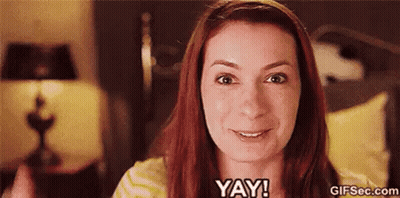 A Woman With Red Hair Is Smiling And Says Yay ! GIF