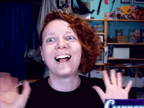 A Woman With Red Hair Is Smiling In Front Of A Box Of Cinnamon GIF