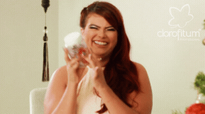 A Woman With Red Hair Is Smiling In Front Of A Logo For Clorofitum GIF