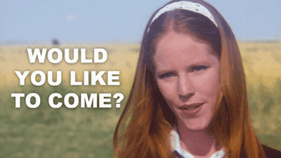 A Woman With Red Hair Is Standing In A Field With The Words " Would You Like To Come " Written Above Her GIF