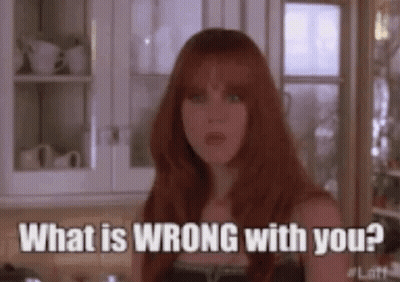 A Woman With Red Hair Is Standing In A Kitchen And Asking What Is Wrong With You ? GIF