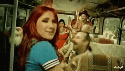 A Woman With Red Hair Is Standing In Front Of A Bus GIF