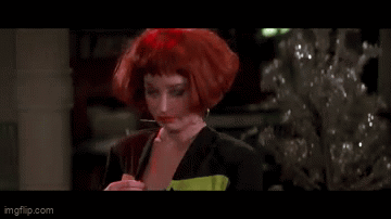 A Woman With Red Hair Is Standing In Front Of A Christmas Tree And Says Typical GIF