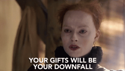 A Woman With Red Hair Is Standing In Front Of A Sign That Says Your Gifts Will Be Your Downfall . GIF