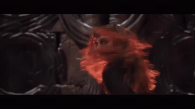 A Woman With Red Hair Is Surrounded By Horns In A Dark Room GIF