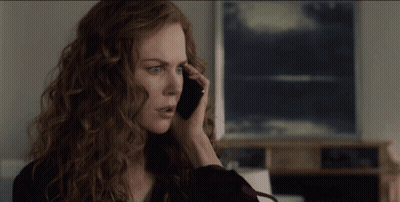 A Woman With Red Hair Is Talking On Her Cell Phone GIF