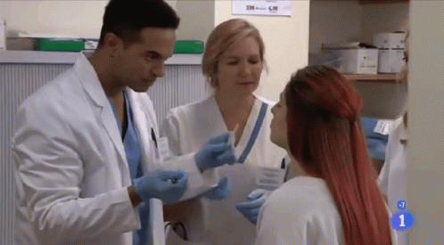 A Woman With Red Hair Is Talking To A Doctor In A Hospital GIF