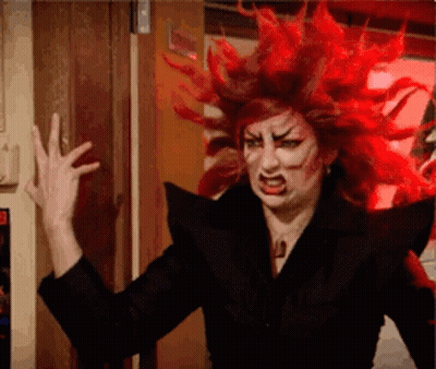 A Woman With Red Hair Is Wearing A Black Jacket And Making A Funny Face . GIF