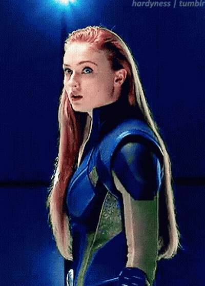 A Woman With Red Hair Is Wearing A Blue And Green Suit GIF
