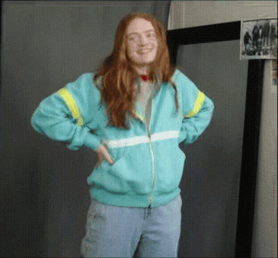 A Woman With Red Hair Is Wearing A Blue Jacket GIF