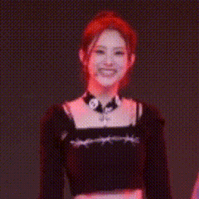 A Woman With Red Hair Is Wearing A Choker And A Black Crop Top . GIF