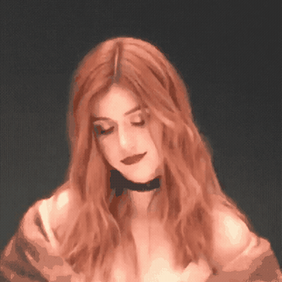 A Woman With Red Hair Is Wearing A Choker GIF