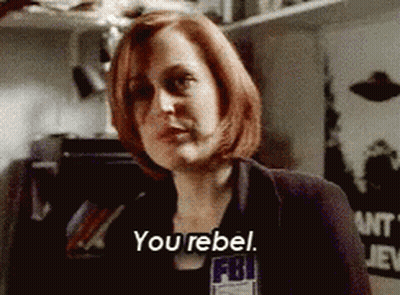 A Woman With Red Hair Is Wearing A Fbi Badge And Says You Rebel GIF