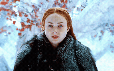A Woman With Red Hair Is Wearing A Fur Coat GIF
