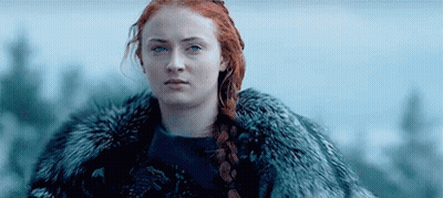 A Woman With Red Hair Is Wearing A Fur Coat And A Braid . GIF