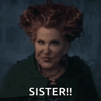 A Woman With Red Hair Is Wearing A Green Cape And A Necklace And Says `` Sister '' . GIF